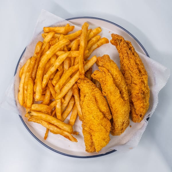 A white plate with a blue rim holds a serving of golden-brown fried fish and french fries.